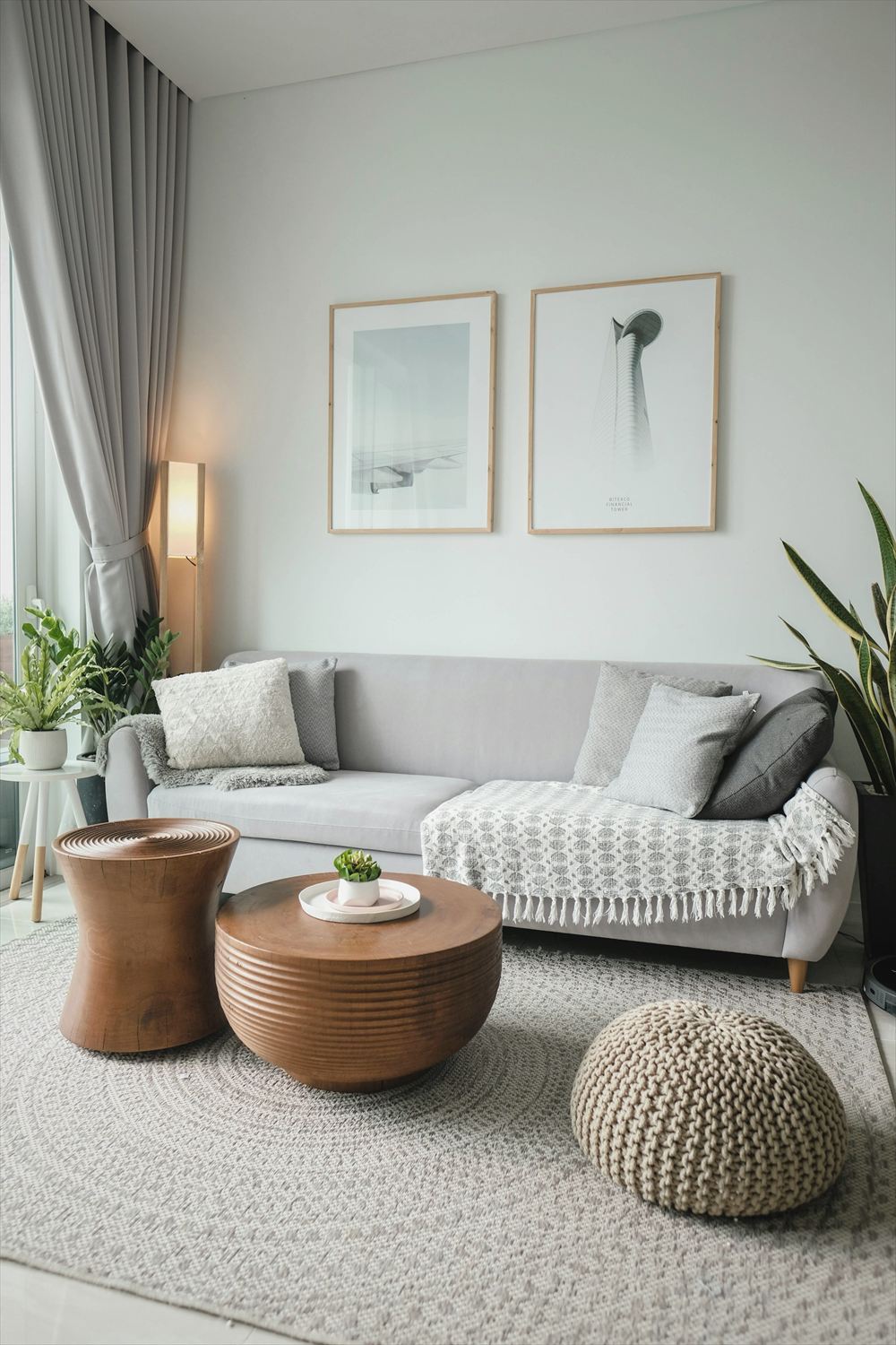 Bright, tidy living room with a grey sofa, plants and a sunny window